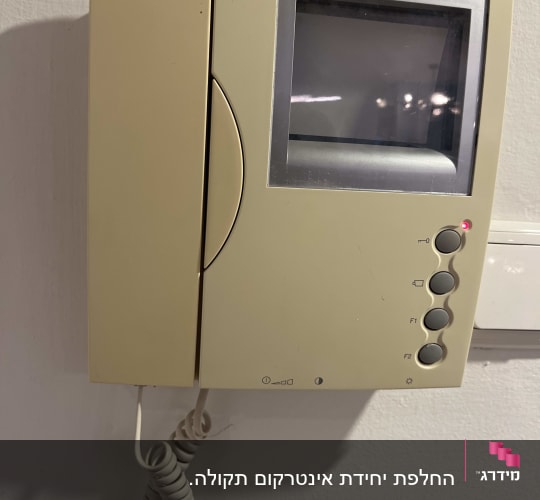 מכשיר אינטרקום מותקן על קיר לבן